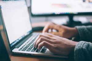 Osoba korzystająca z laptopa, ilustracja dostępności strony i wytycznych WCAG