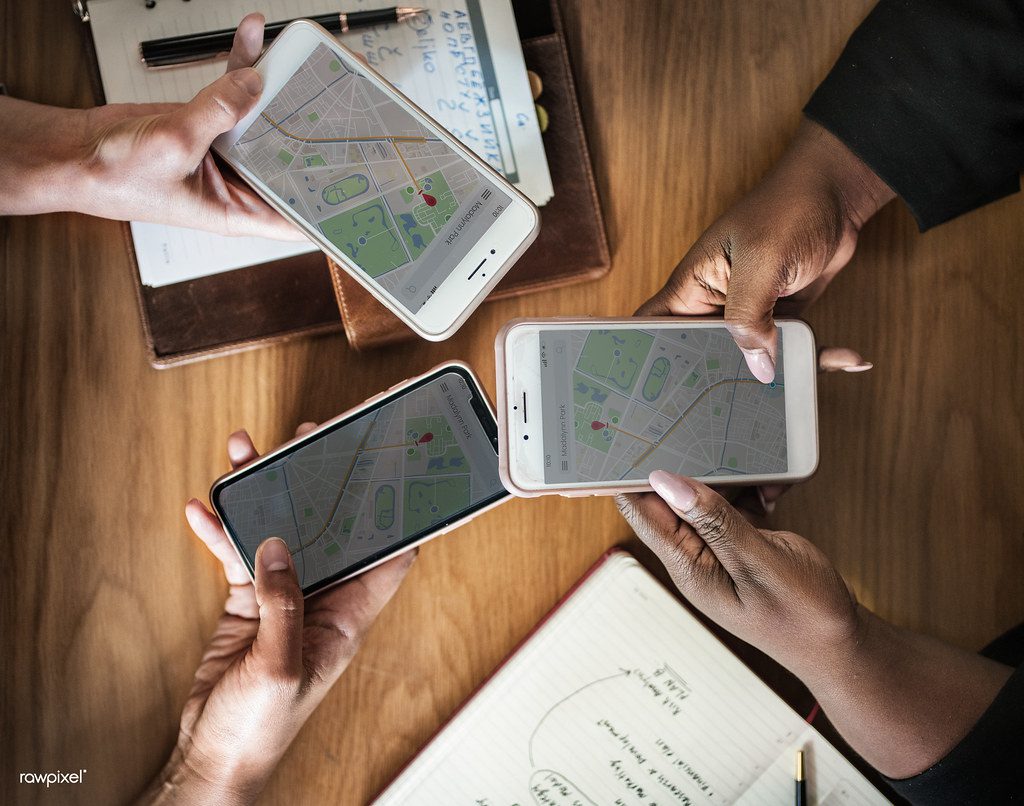 Osoby sprawdzające mapę z lokalizacją na telefonach