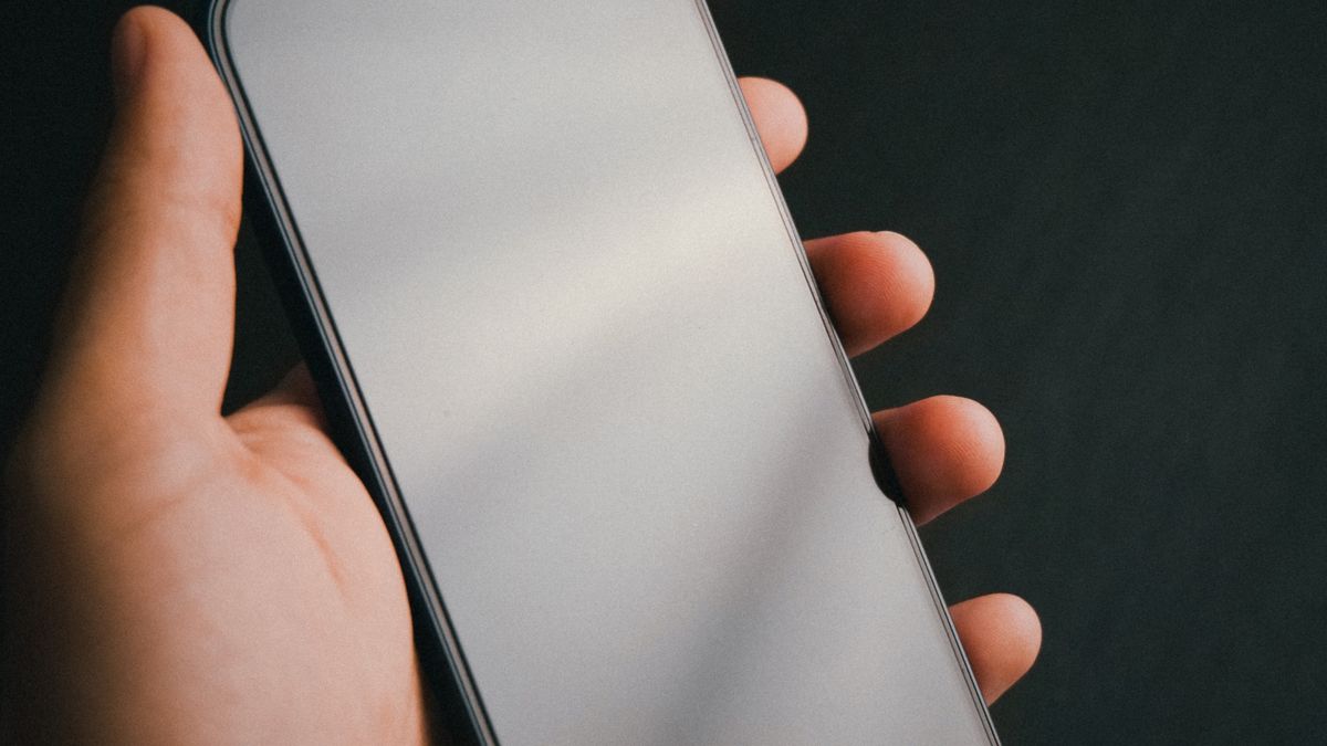 Dłoń trzymająca smartfon z pustym, wygaszonym ekranem