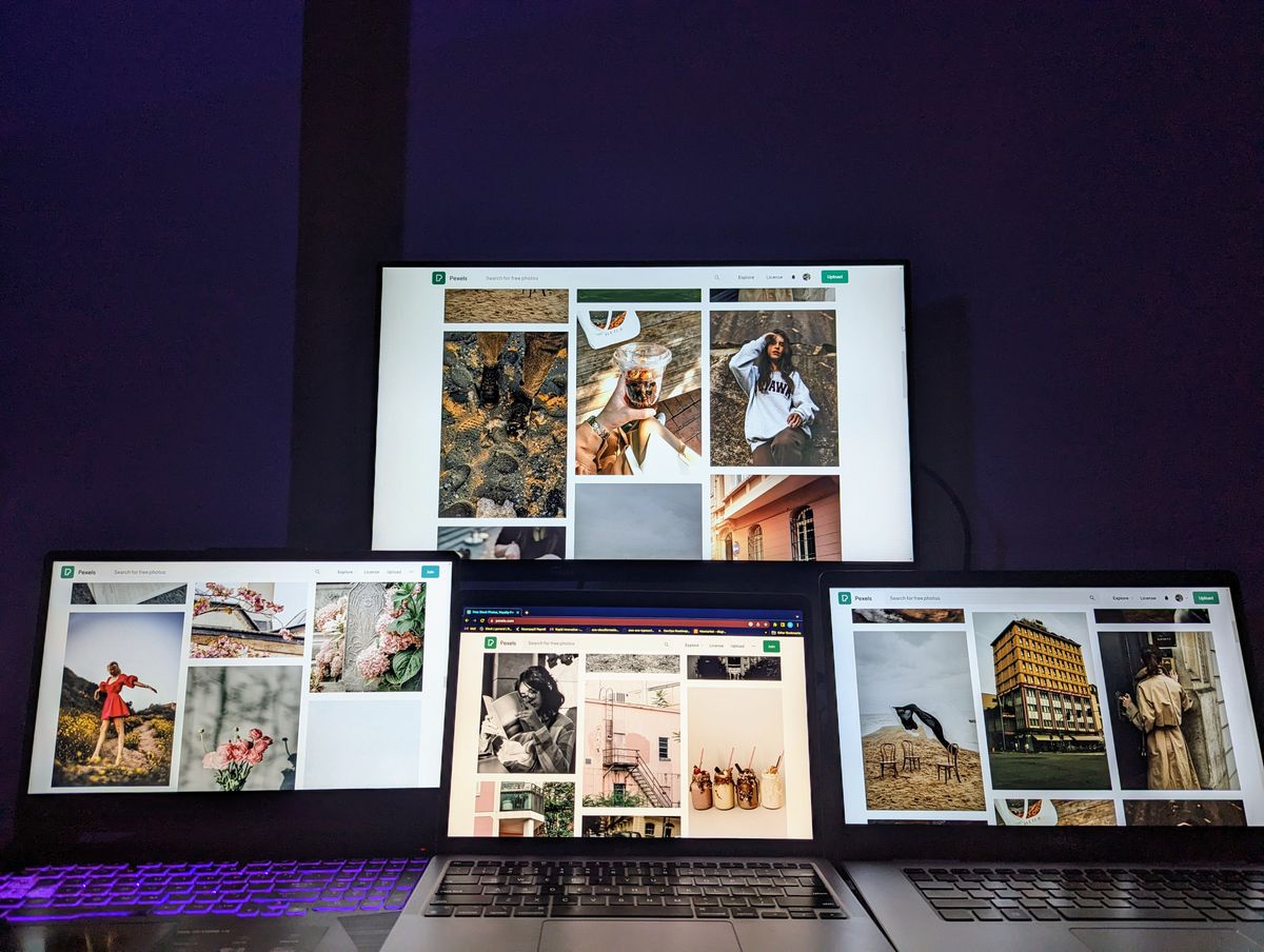 Trzy laptopy o różnych przekątnych ekranu i monitor ustawione obok siebie
