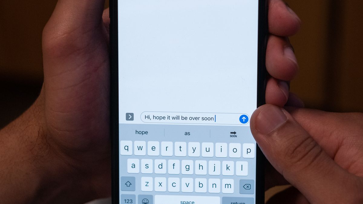 Dłonie trzymające smartfon z otwartą rozmową w aplikacji wiadomości
