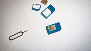 Karty SIM w kilku formatach obok igły do wysuwania tacki