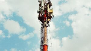 Maszt telekomunikacyjny z antenami sektorowymi na tle nieba