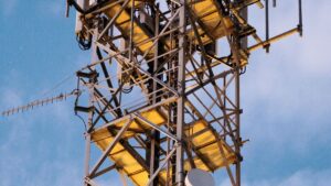 Maszt telekomunikacyjny z antenami sektorowymi na tle nieba