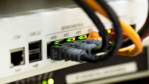 Porty LAN routera z podpiętymi kablami Ethernet i zapalonymi diodami