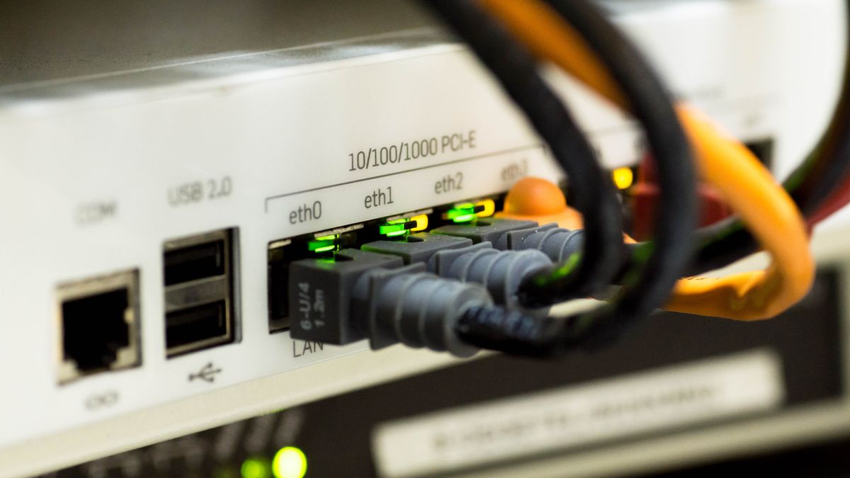 Porty LAN routera z podpiętymi kablami Ethernet i zapalonymi diodami