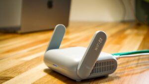 Domowy router Wi-Fi z antenami i podłączonym kablem sieciowym na biurku