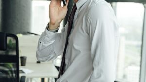 Mężczyzna w koszuli rozmawiający przez telefon w biurze