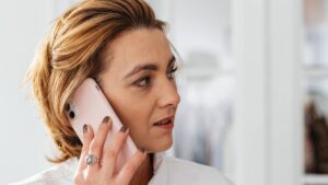 Kobieta rozmawiająca przez telefon w domowym wnętrzu