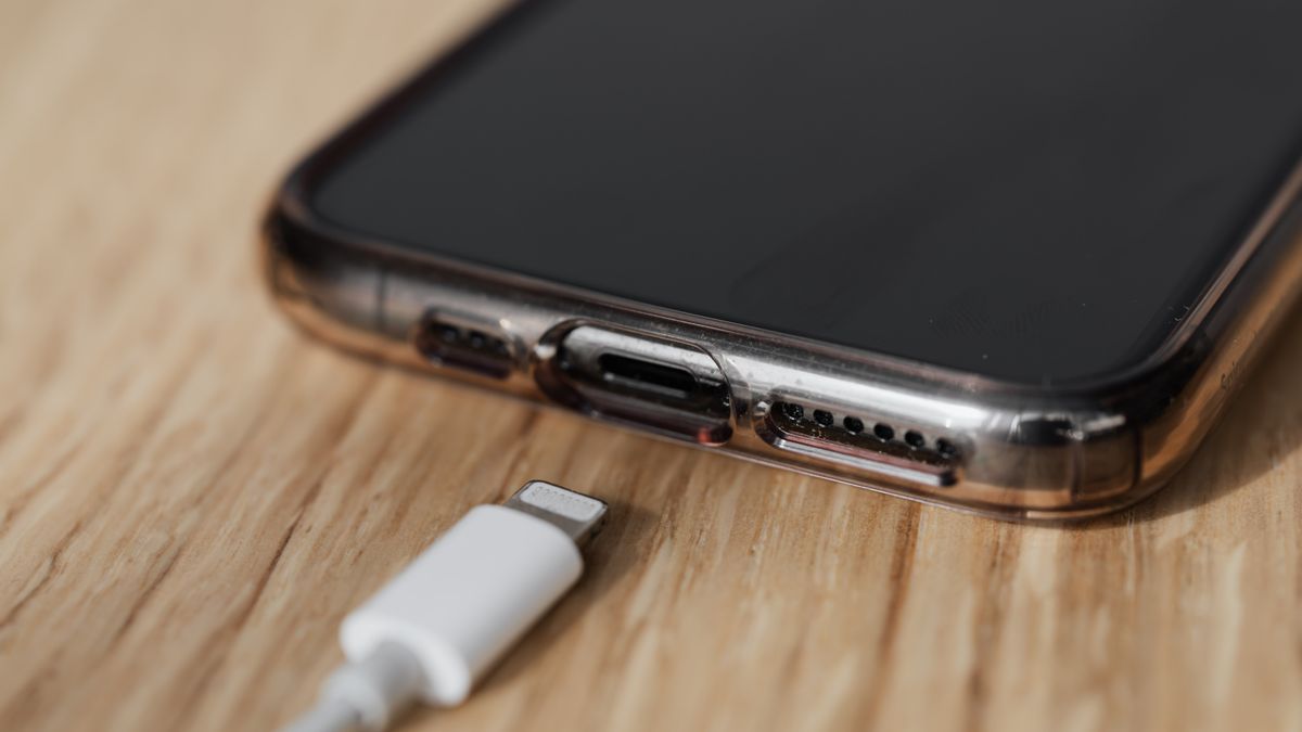 Zbliżenie na gniazdo ładowania smartfona i odłączony biały kabel