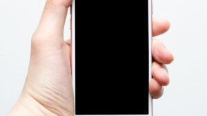 Dlon trzymajaca telefon z czarnym, wygaszonym ekranem