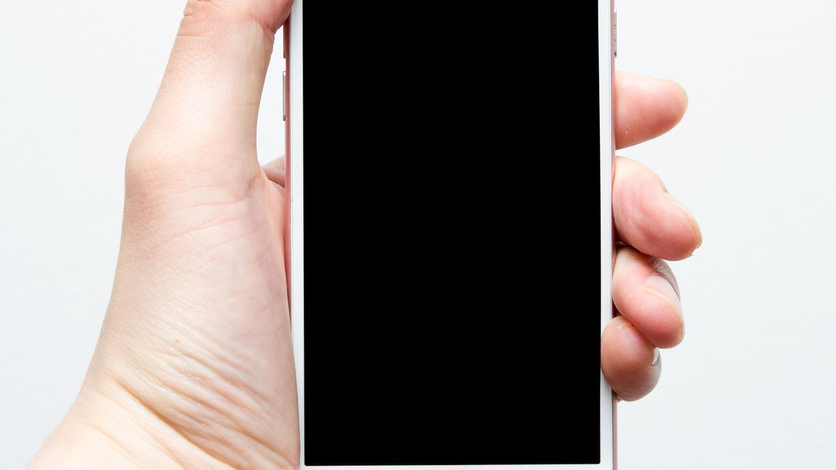 Dlon trzymajaca telefon z czarnym, wygaszonym ekranem