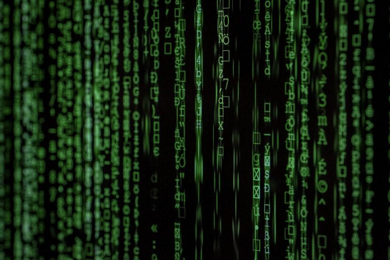 Strumień kodu na ciemnym monitorze, ilustracja zagrożeń typu malware