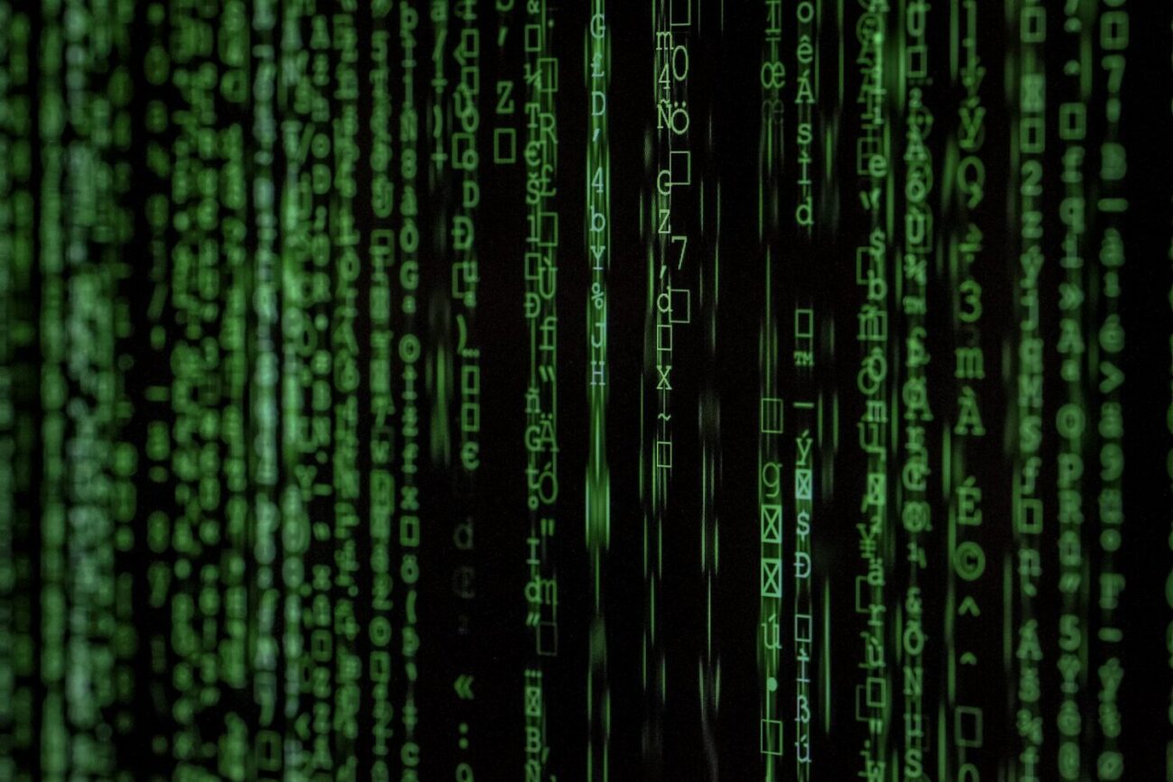 Strumień kodu na ciemnym monitorze, ilustracja zagrożeń typu malware