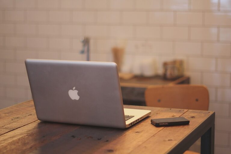 MacBook i iPhone na biurku gotowe do przesyłania plików przez AirDrop