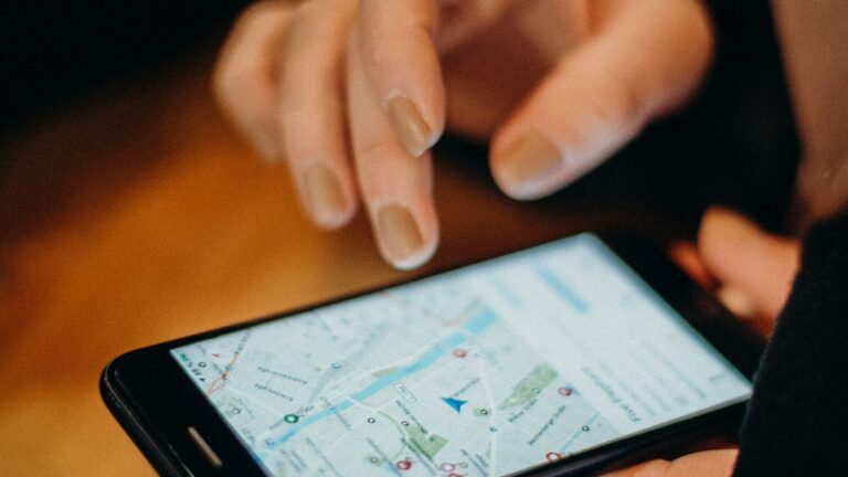 Dłoń obsługująca mapę wyświetloną na ekranie smartfona