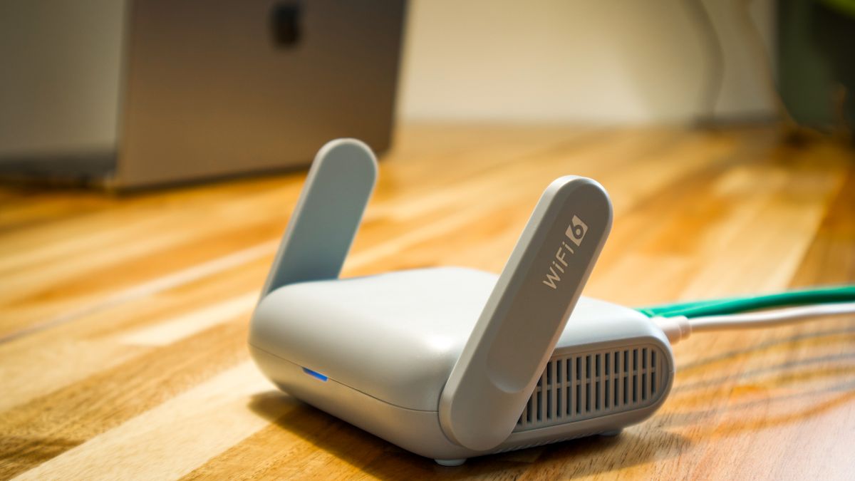 Domowy router Wi-Fi z antenami i podłączonym kablem sieciowym na biurku