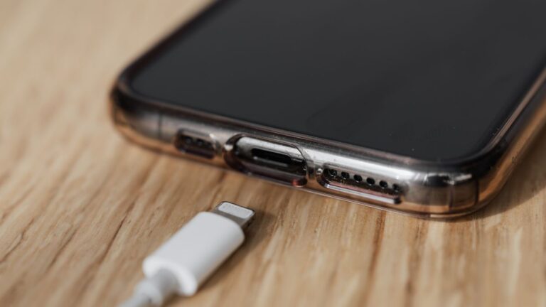 Zbliżenie na gniazdo ładowania smartfona i odłączony biały kabel